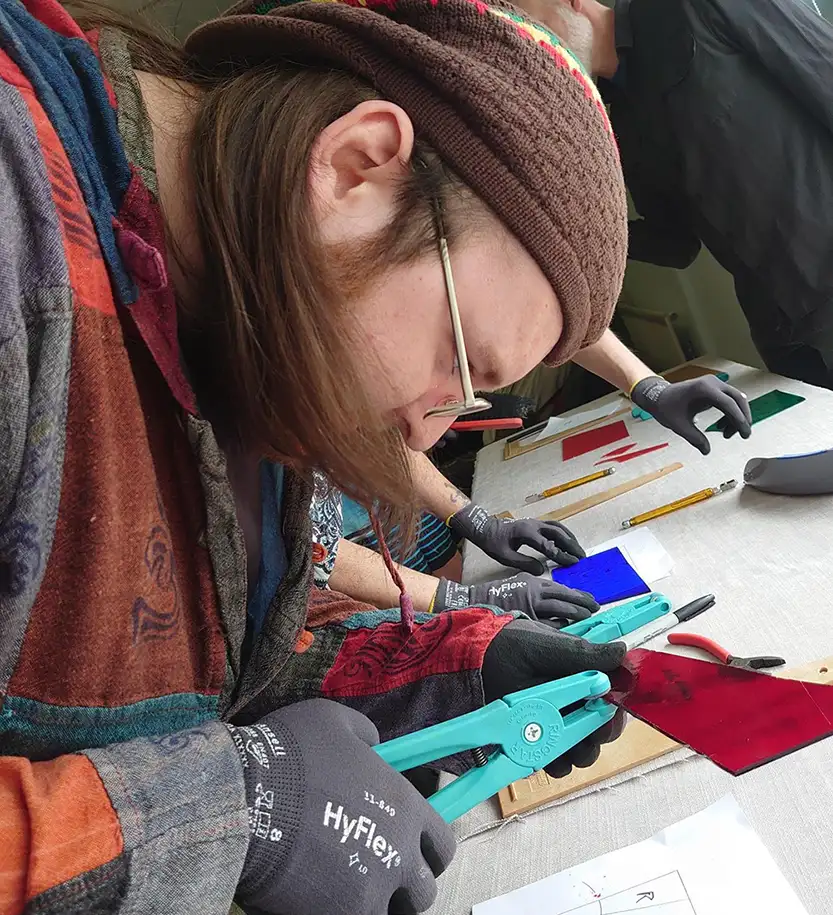 Person cutting stained glass with pliers.